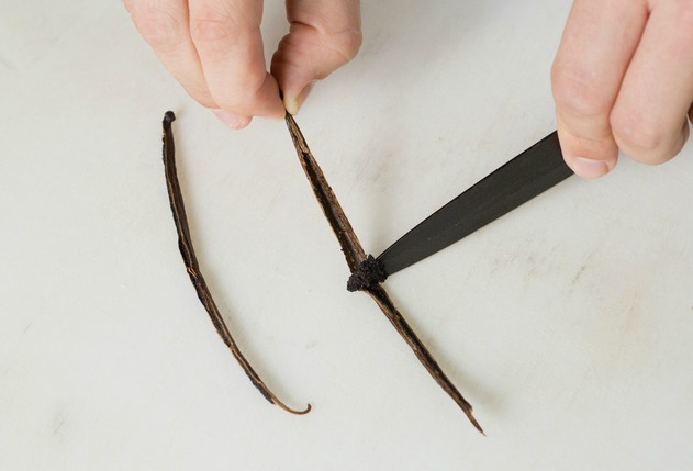 Scooping out vanilla beans using a knife.