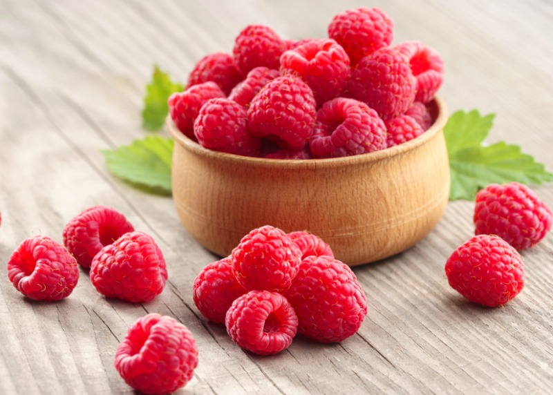 An overflowing bowl of fresh raspberries