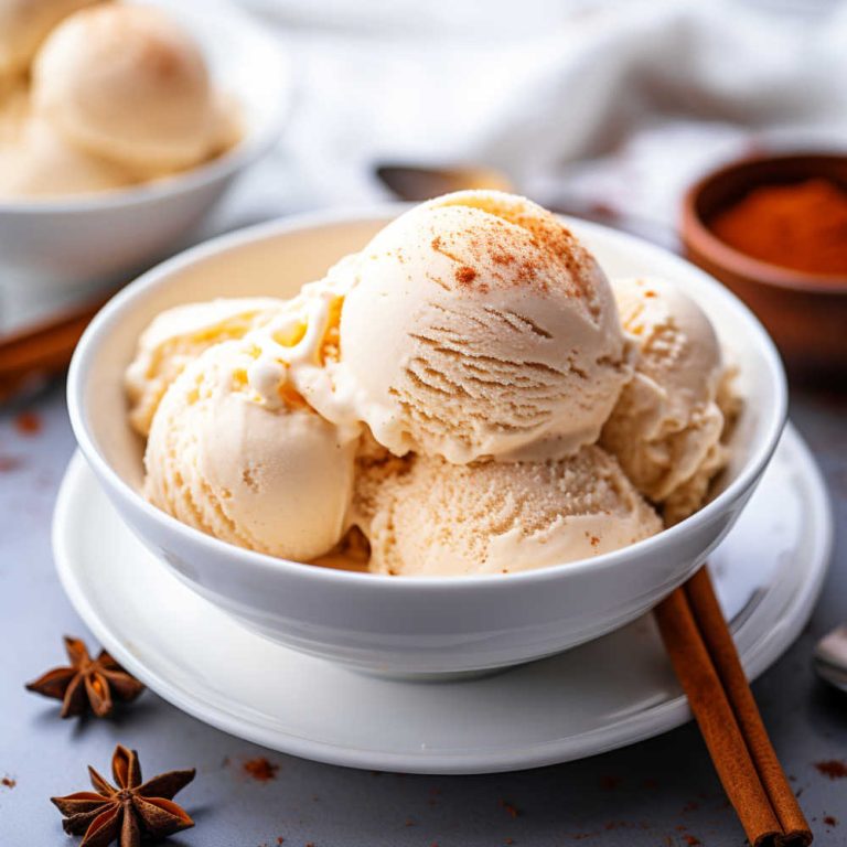 Scoops of cinnamon ice cream in a white bowl on a table.