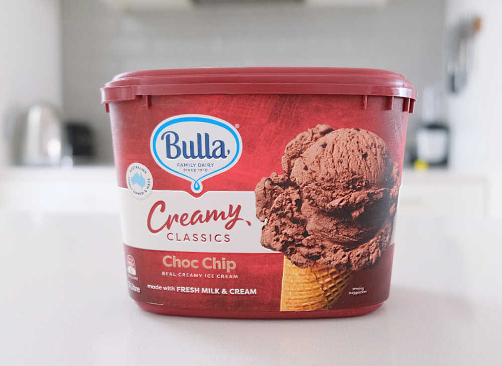 A tub of Bulla Creamy Classics Choc Chip Ice Cream on a kitchen bench.