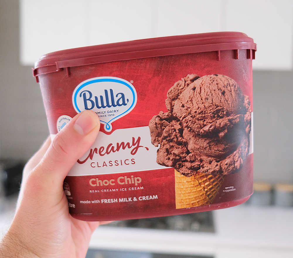Holding a container of Choc Chip Ice Cream by Bulla.